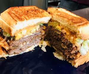 The "Big W" - Two Burgers stacked between two Grilled Cheeses, lettuce, onions, cheese & thousand island dressing.